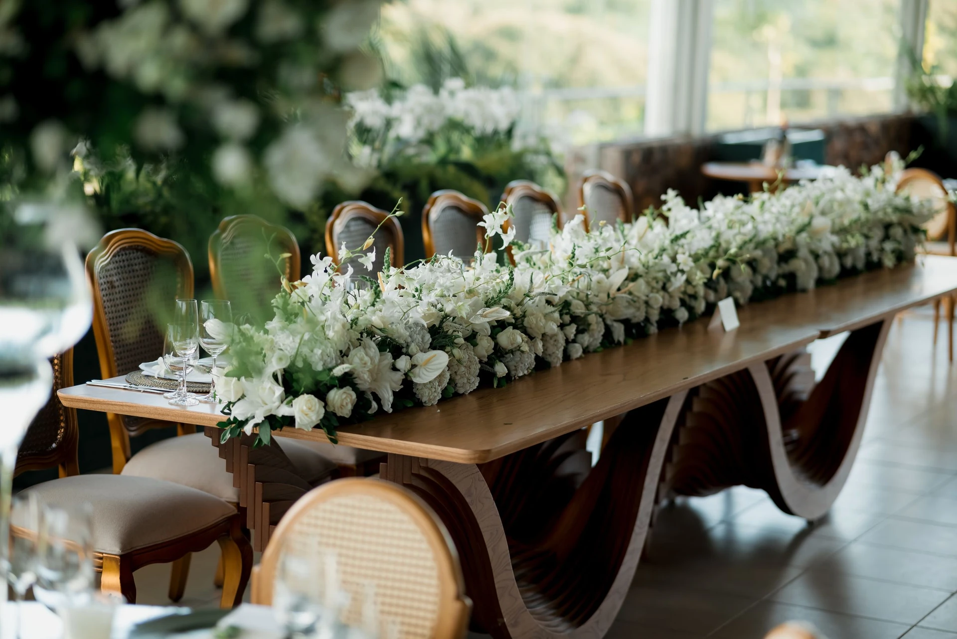 Mesa larga con camino de flores blancas