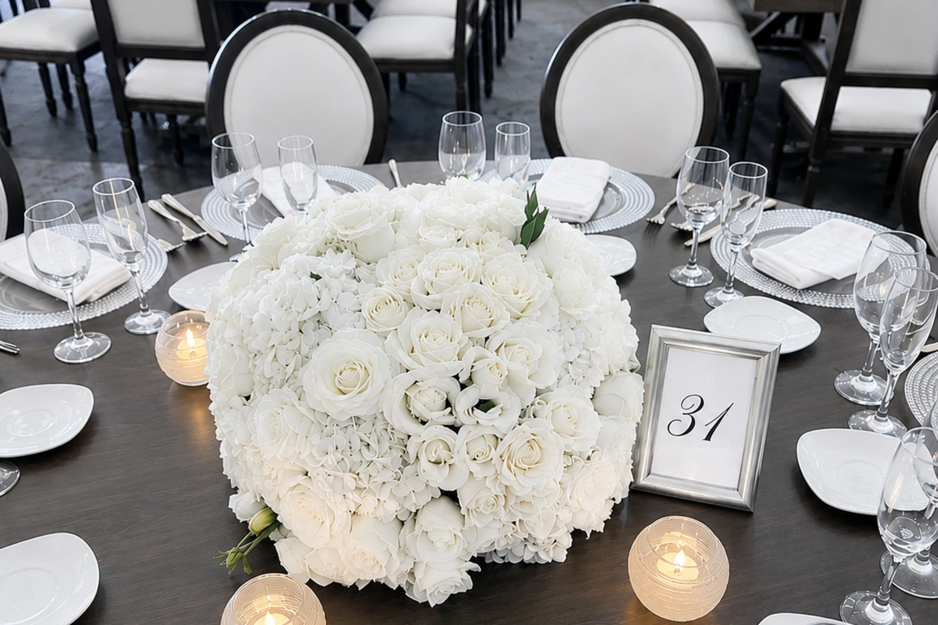Centro de mesa de rosas blancas en una mesa de banquete